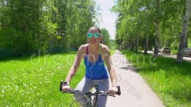 女人骑着一辆带智能手表心率监视器的自行车。 智能手表的概念。 戴眼镜的快乐年轻女子